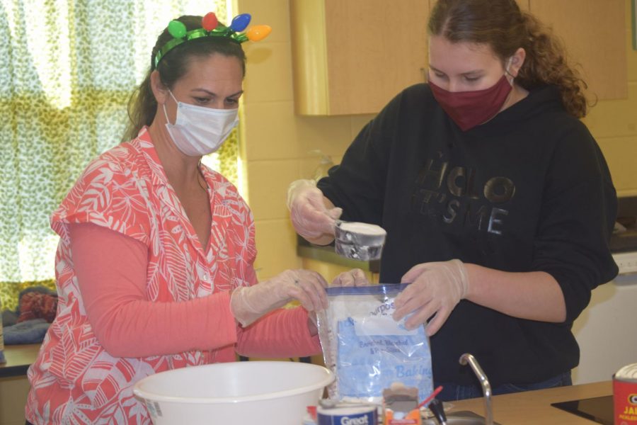 Mrs. Gorcesky measures out flour with Sydney Alderman.