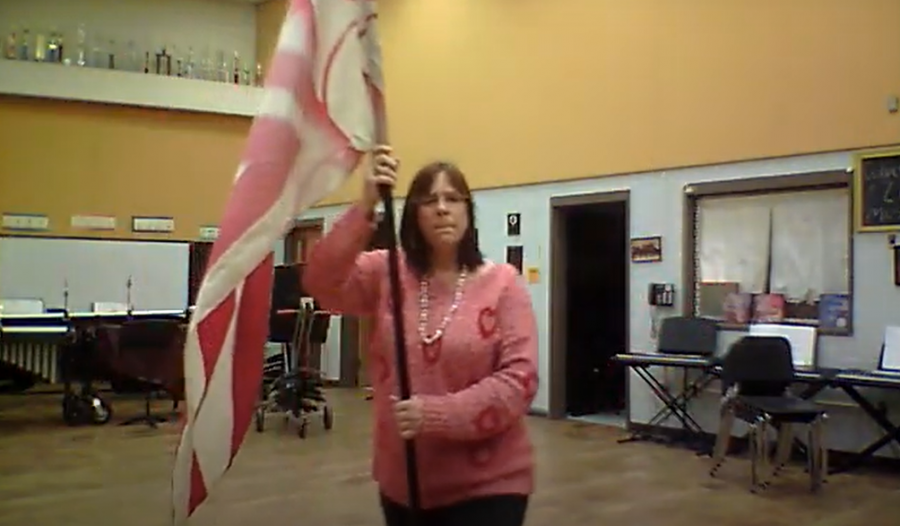 Mrs. Polenick demonstrates a color guard routine.
