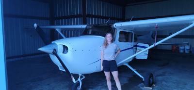 Amber Nophsker stands next to the C 172S plane she learned how to fly this summer.