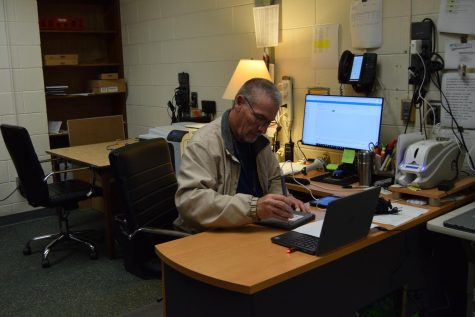 Technology assistant Mr. Chuck Rhue works on a student-issued laptop, one of many he has had to work on this year.
