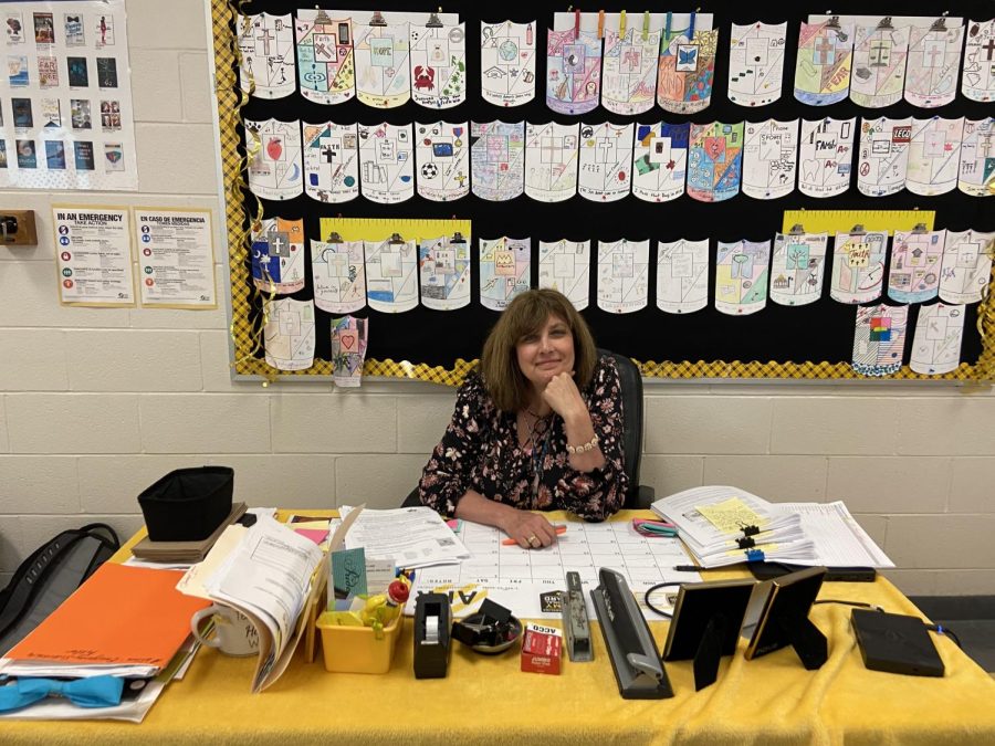 Ms. Amy Wilson sits at her desk in Room 212 between classes.