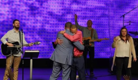 Coach Derrick Hilton hugs the Rev. Jamie Barfield, pastor at Palmetto Pointe Church of God, after he announced the church was giving him $30,000 to help him battle cancer.