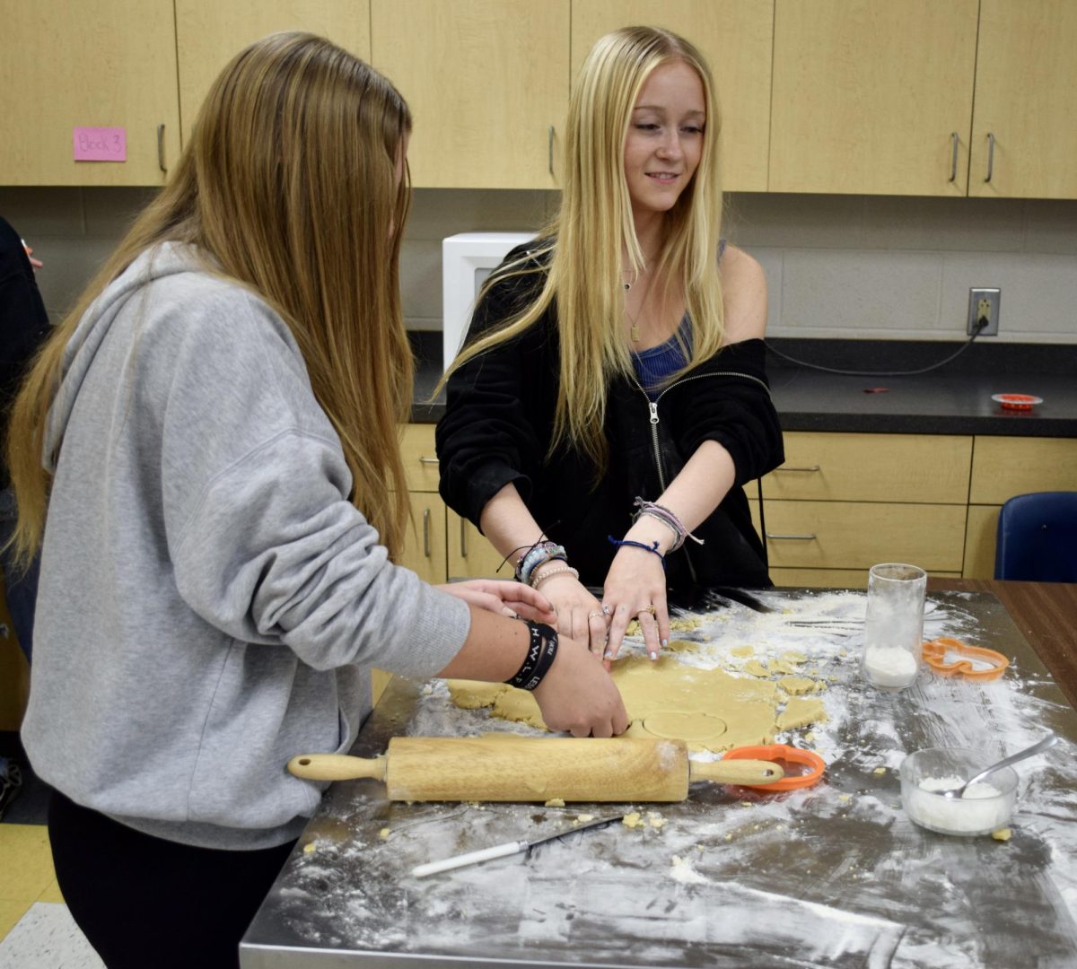 Students roll out cookie dough.