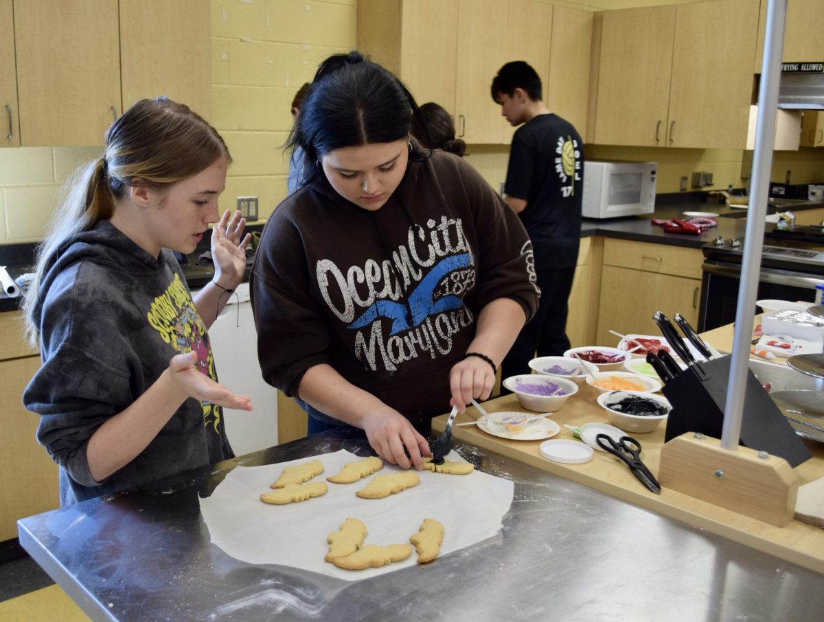 Students decorate Halloween themed cookies.