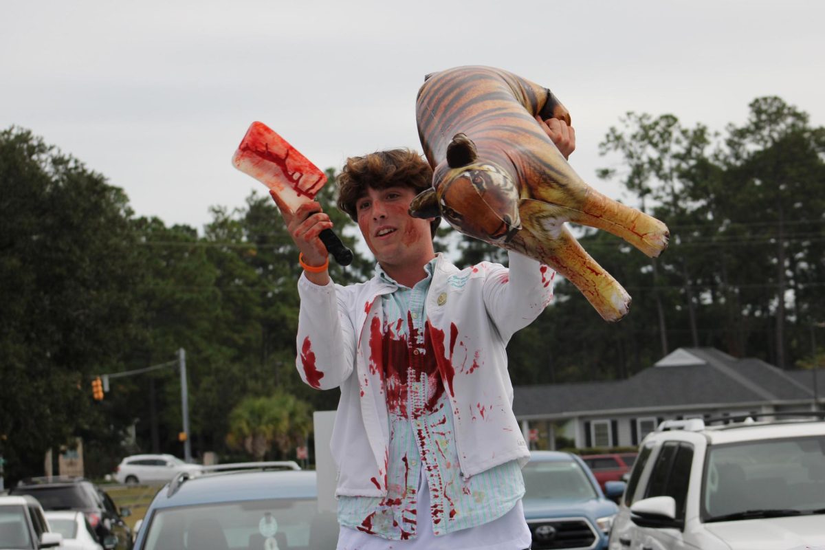 Junior Ben Malone symbolically kills a tiger on his float.