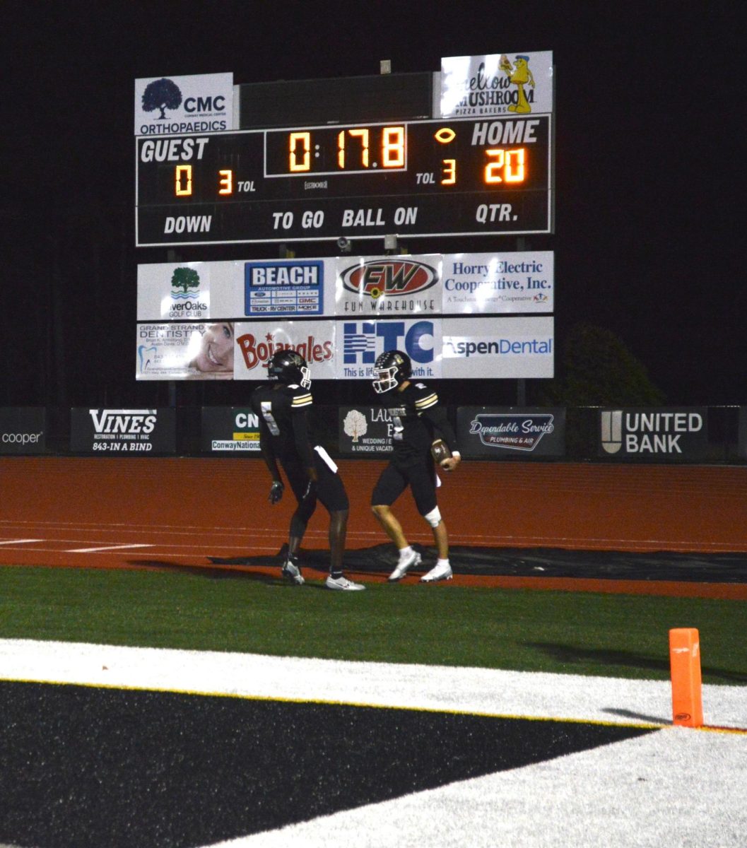 Rocco Wojcik (12) and Josh Brown (11) celebrate a long touchdown to go up 20-0 versus Wando. The team ended up winning 47-7, which advanced them to the playoffs.