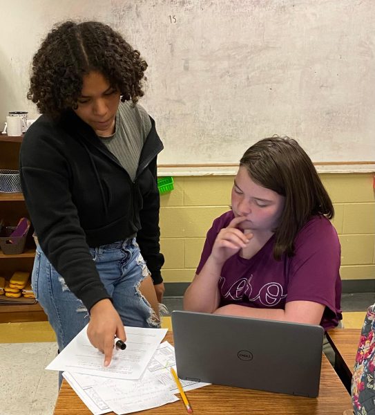 Freshman students help each other solve math problems in Algebra 1. 