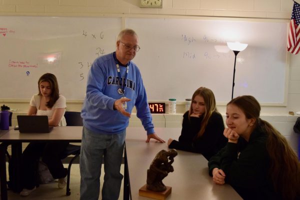 IB French Teacher Mr. Danny Wilson shows students a statue of The Thinker, which was the first graduating class mascot. Mr. Wilson brought the IB program to Socastee in 1997.