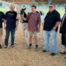Participants at the Lewis County Fair gather with a Holstein cow for a fundraiser supporting ALICE families